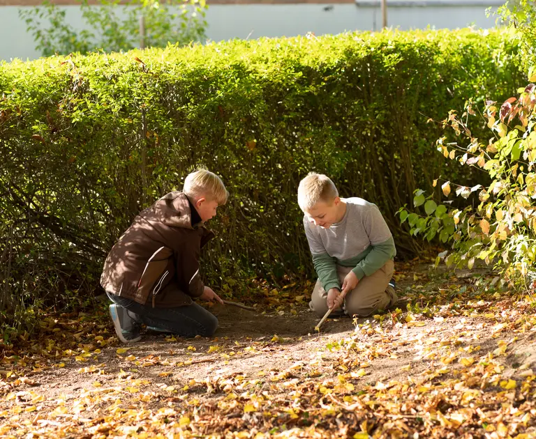 Zwei Schüler spielen zusammen im Garten