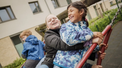 Mehrere Schüler spielen zusammen auf der Schaukel