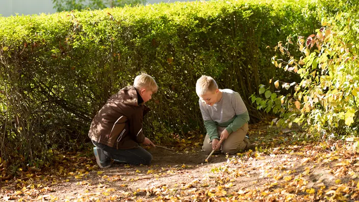 Zwei Schüler spielen im Garten