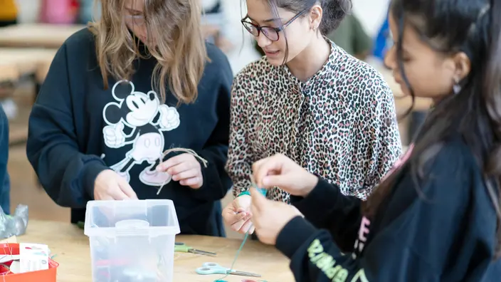 Mehrere Schülerinnen basteln zusammen.